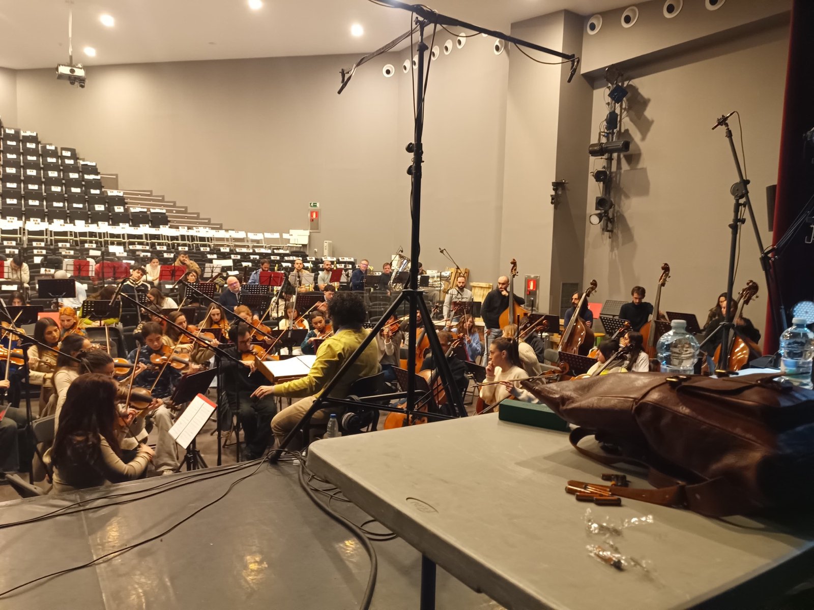 Gran formación musical trabajando con dirección y microfonía durante una sesión de grabación