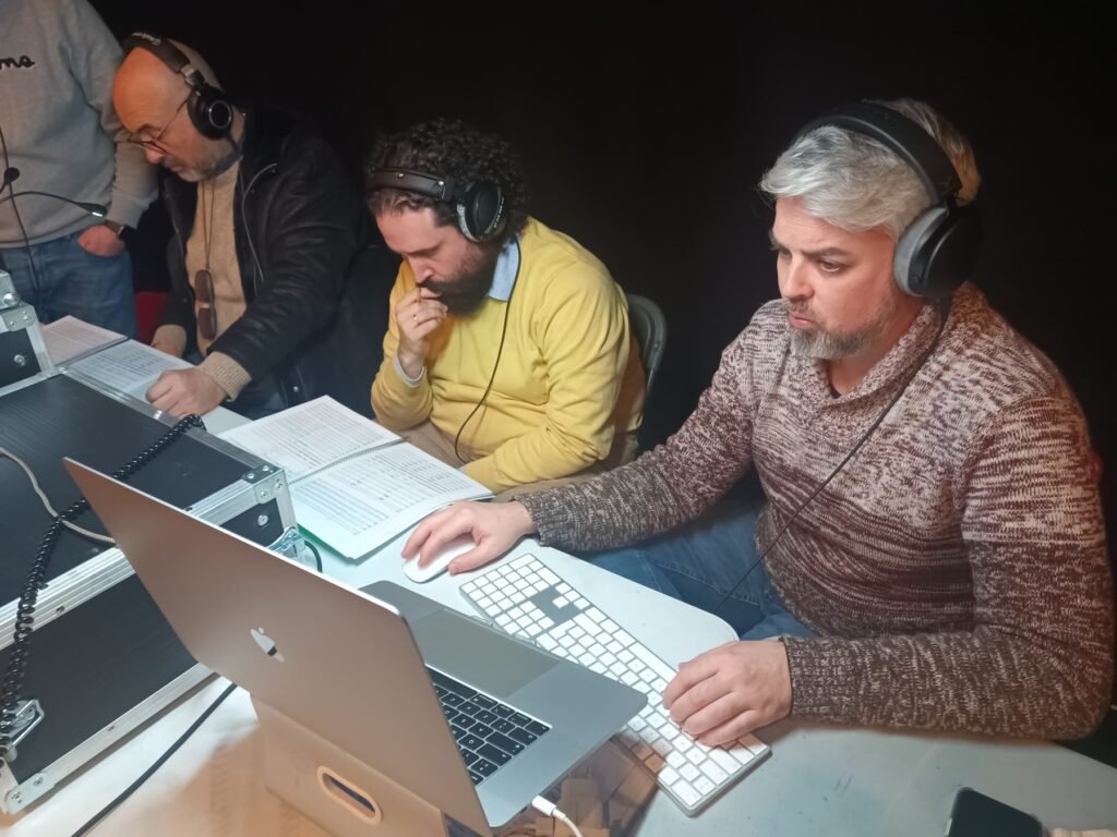 Equipo revisando una partitura y una sesión durante una producción musical